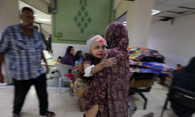 A girl holds tight to a woman in a Gaza hospital 