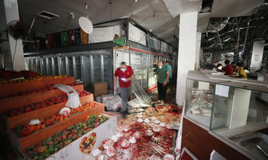Men wearing face masks stand in aisles of supermarket covered with blood with empty refrigerator displays behind them