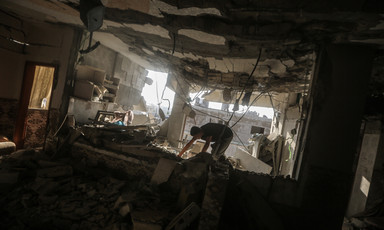 A man searches through a building that has been bombed in the Khan Younis area of Gaza. 