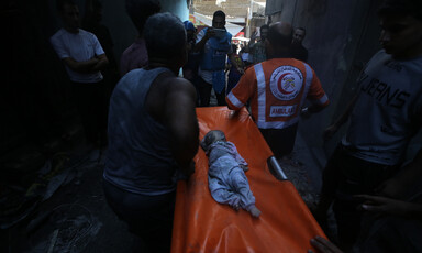 paramedics carry a stretcher with the body of a baby