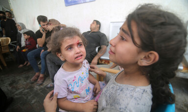 A crying toddler and a young girls wait for medical attention