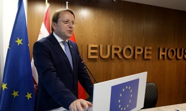 Member of the European Commission Oliver Varhelyi stands at a lectern, the sign behind him reads Europe House 