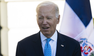 President Joe Biden with a flag behind him