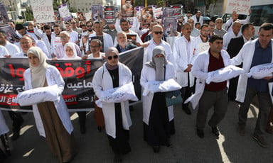 A street protest of doctors carrying props of infants in body bags