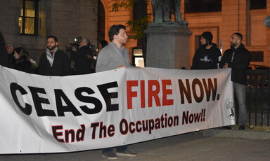 People stand with a banner calling for a ceasefire