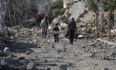 A few people walk through rubble in the Khan Younis area of Gaza 