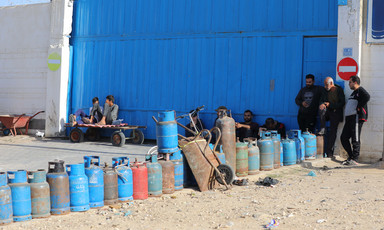 A few men stand beside a row of cooking gas cylinders in southern Gaza 