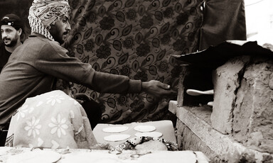 Man reaches for freshly baked bread