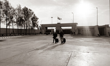 Two people walk across an empty courtyard