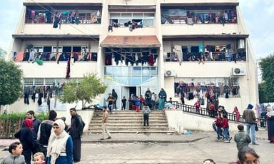 Clothes can be seen hanging from the balconies of and many people can be seen near the entrance of the Palestine Technical College in central Gaza  