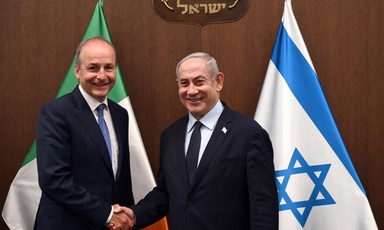 Foreign Minister of Ireland Micheal Martin shakes hands with Israel's Prime Minister Benjamin Netanyahu in front of flags  