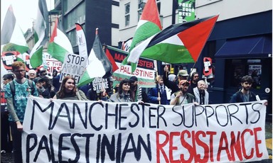 A protest with a banner reading "Manchester Supports the Palestinian Resistance."