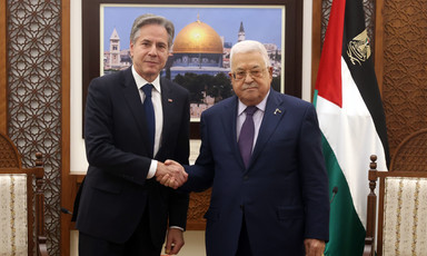 Blinken and Abbas shake hands in front of a framed picture of Jerusalem's Dome of the Rock