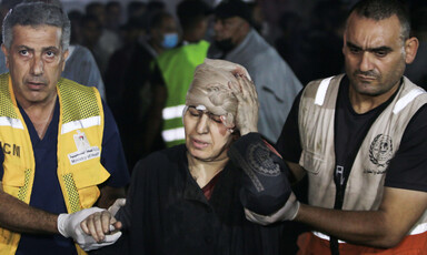 A woman in distress is guided by two emergency workers