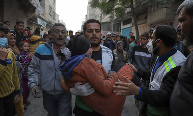 An injured Palestinian is carried as people look on