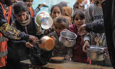A large number of children wait for a small amount of food in the southern Rafah city of Gaza 