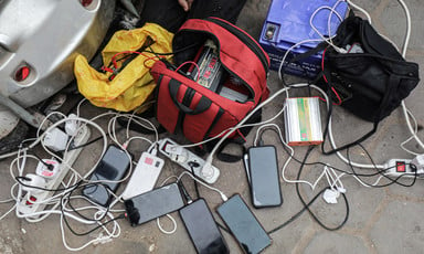 On the ground, a tangle of cellphones charging