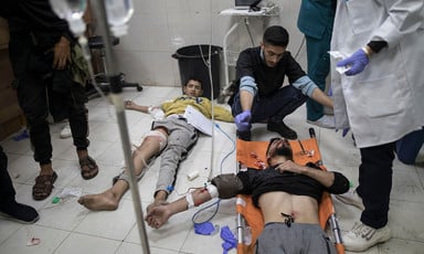 One patient lies on the floor and another lies on a stretcher at Nasser Medical Complex in southern Gaza 