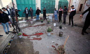 Men stand arround blood spilled on the ground 