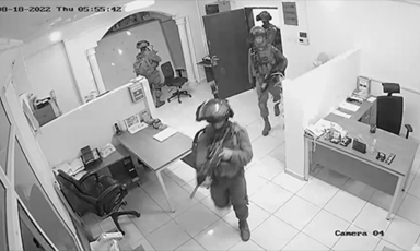 Black and white still of armed soldiers in an office aBlack and white still of armed soldiers in an office
