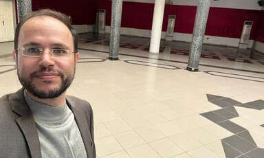 A man takes a selfie in an empty hall