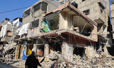 A man and a woman walk beside what remains of a building in Gaza 