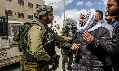 An Israeli soldier grabs the arm of a Palestinian demonstrator