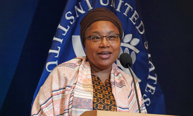 Alice Wairimu Nderitu stands at a podium with logo of U.S. Institute of Peace behind her