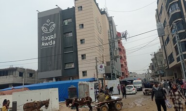 A number of people walk outside al-Awda hospital in central Gaza 