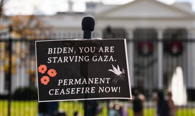 A sign in front of the White House accuses Joe Biden of starving Gaza