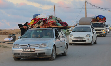 Cars and vans with many items packed on their roofs 