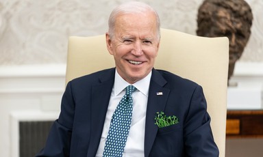 US President Joe Biden smiles as he wears shamrock in his jacket pocket 