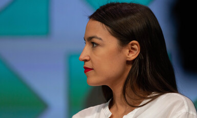 Side profile of a woman with long black hair and a white shirt 