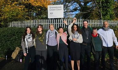 Eight people stand in front of a sign reading Snaresbrook Crown Court 