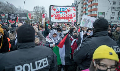 Police stand in front of protesters in Berlin