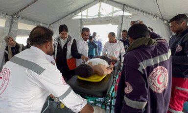 Medics in a Gaza tent attend to a patient on a stretcher 