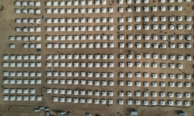 Bird's-eye view of rows of small tents on desert land