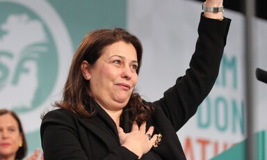 Palestinian Authority representative Jilan Wahba Abdalmajid waves in front of a green and white backdrop showing the letters SF