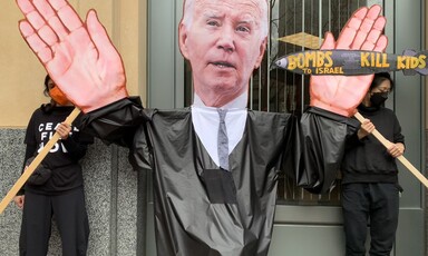 Protesters hold up a giant puppet of Joe Biden with the words "bombs to Israel kill kids" painted on a missile in the puppet's hand