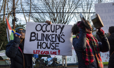 Protestors hold a sign reading: Occupy Blinken's house
