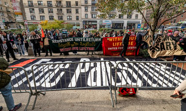 People gather around a banner reading Free Palestine and other banners in New York's Columbia University 