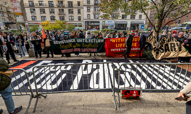 People gather around a banner reading Free Palestine and other banners in New York's Columbia University