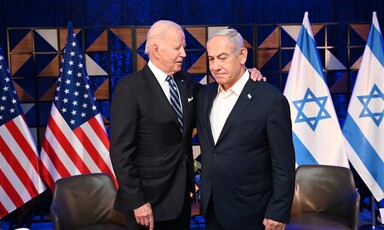 President Joe Biden puts his arm around Prime Minister Benjamin Netanyahu with American and Israeli flags behind them