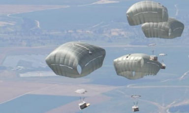 Aerial image of parachutes descending onto land 