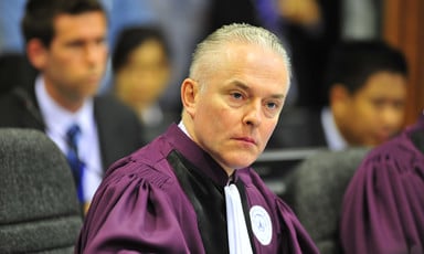 British lawyer Andrew Cayley wearing purple and white robes 