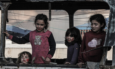 Four children play in the wreckage of a bus