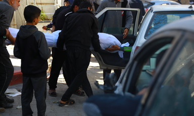 A dead body is carried by a number of people following an Israeli massacre in Gaza 