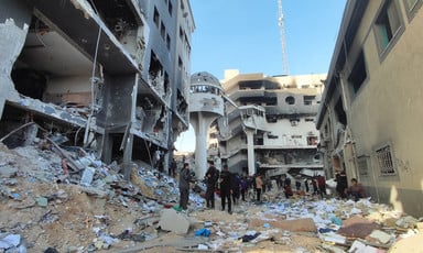 People stand in what remains of the area around Gaza's largest hospital 
