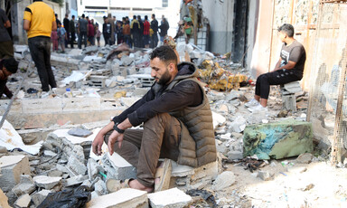 A man sits amid the rubble in Rafah