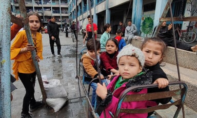 Children play on swings at a Gaza school that has been turned into a shelter. 